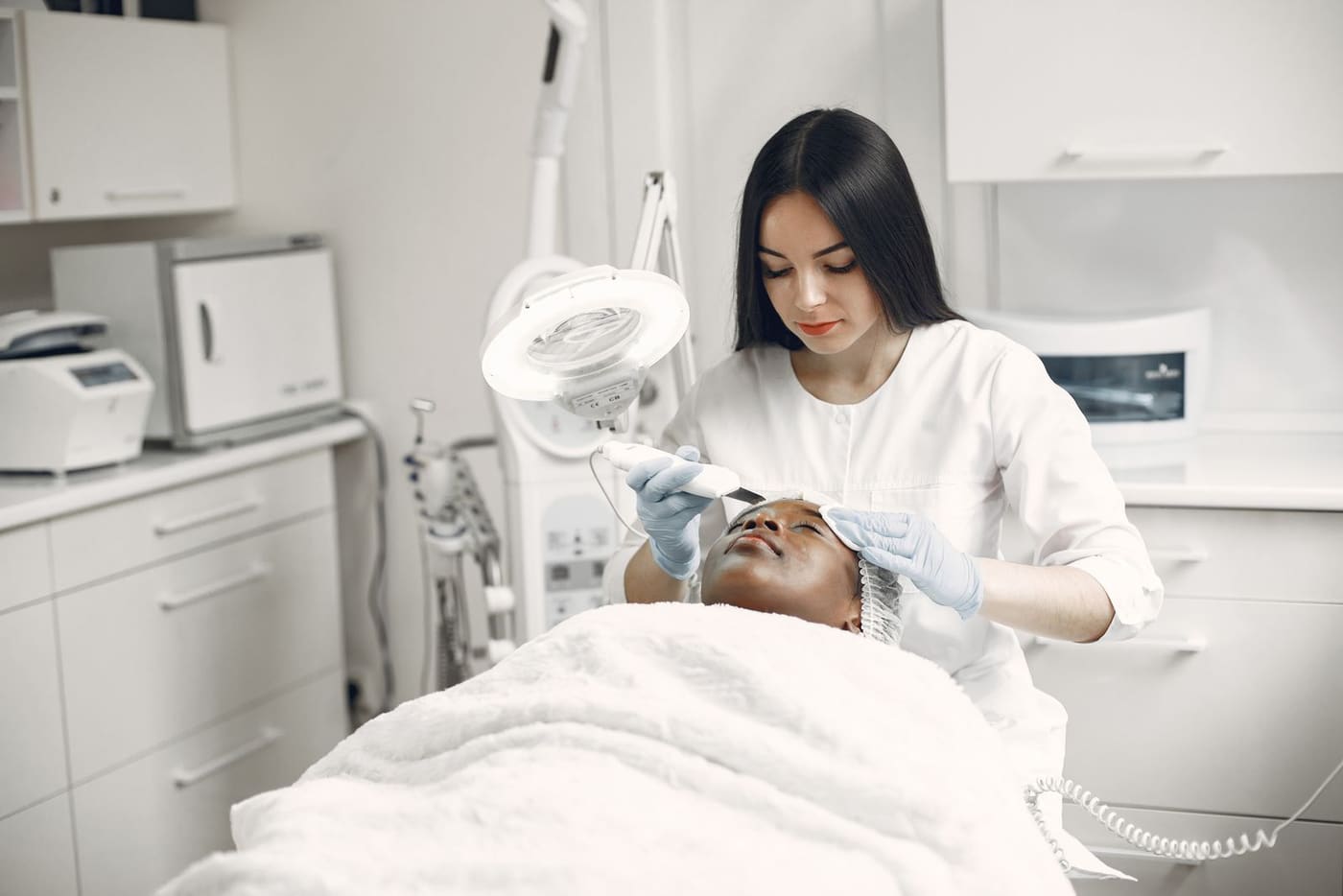 Profissional aplicando aparelho de alta frequência em tratamento facial
